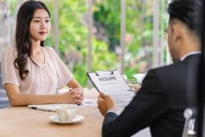 Young woman graduate interviewing with two managers